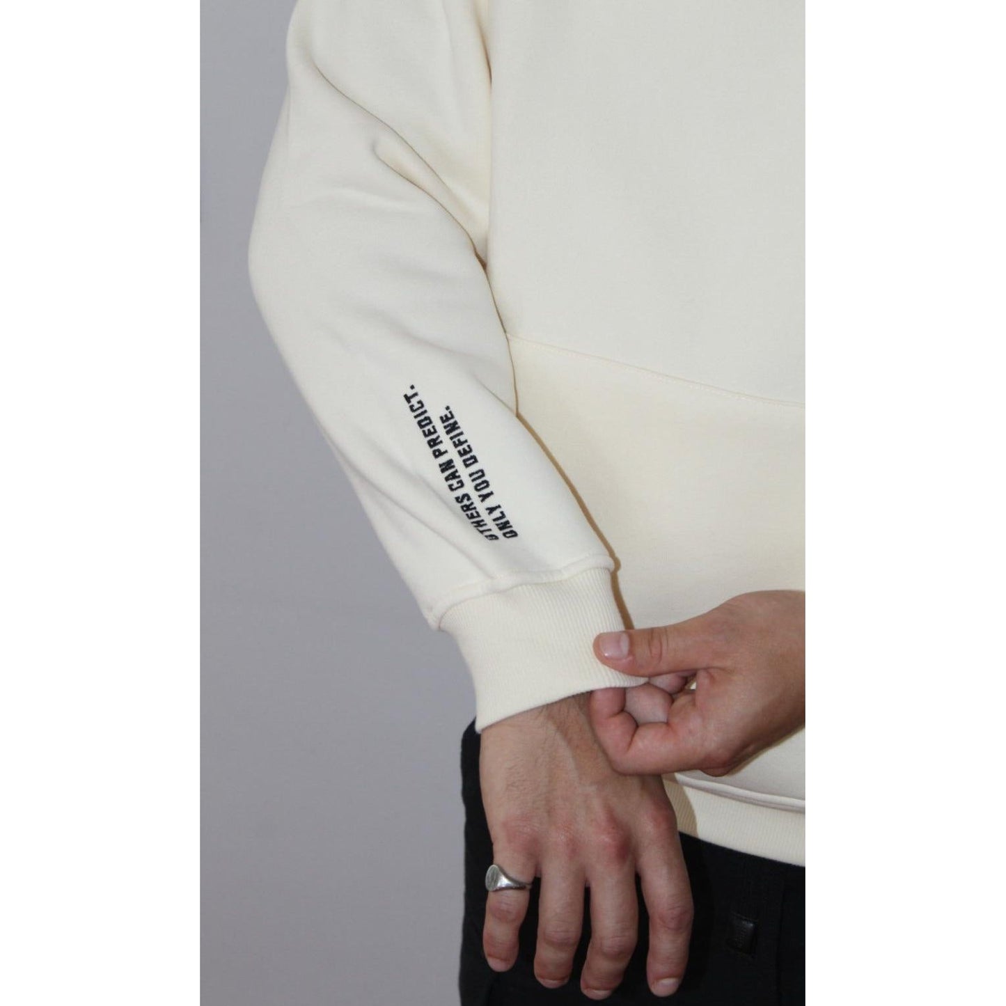 Close-up of Legacy29 Cloud 9 cream hoodie sleeve with printed text. Premium soft fabric with a resilience-inspired message for motivation and style.