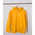 Legacy29 Golden Glow Yellow hoodie hanging on a wooden hanger. Soft, oversized fit with front pocket and embroidered logo for a stylish, cozy look.