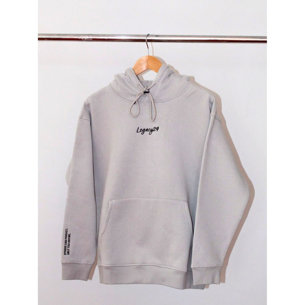 Legacy29 Resilience Collection: Silver Linings Grey Comfort Hoodie hanging on a wooden hanger. Soft fabric with embroidered logo on chest.
