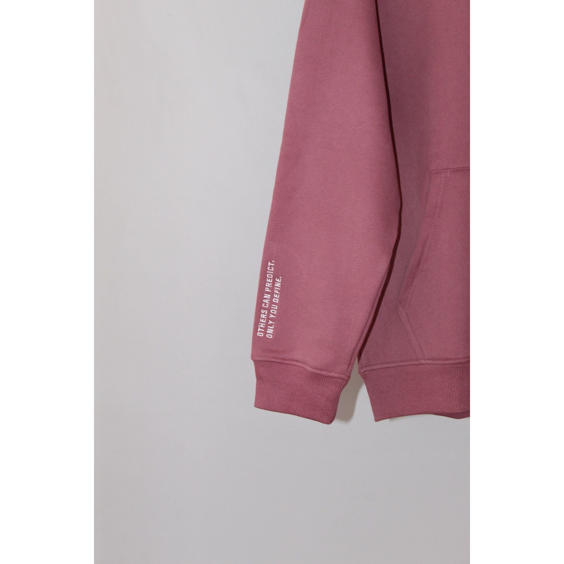 Close-up of Legacy29 Resilient Ruby Red Hoodie sleeve with printed text detail. Premium fabric and design for warmth and motivation.