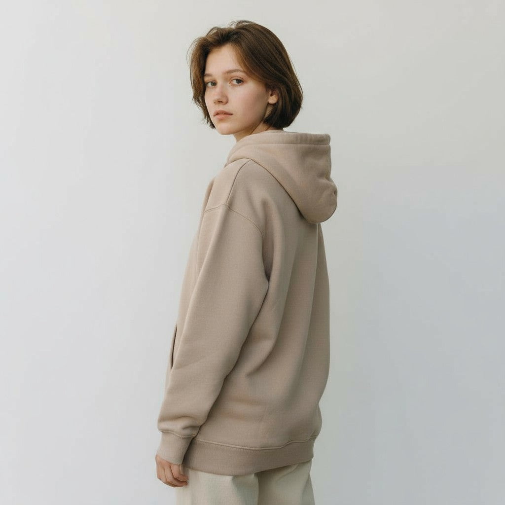 Person wearing a beige hoodie against a plain background