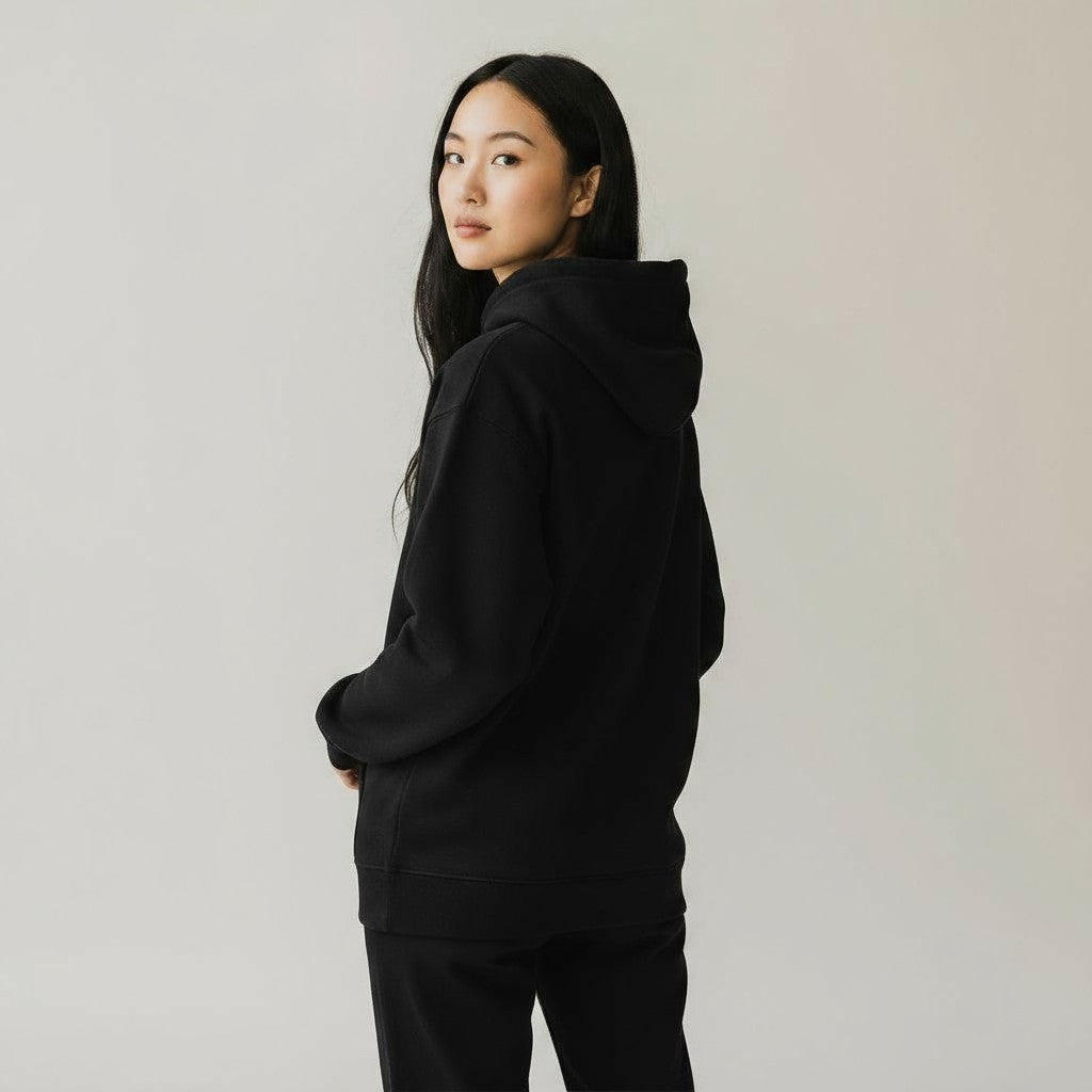 Person wearing a black hoodie against a plain background