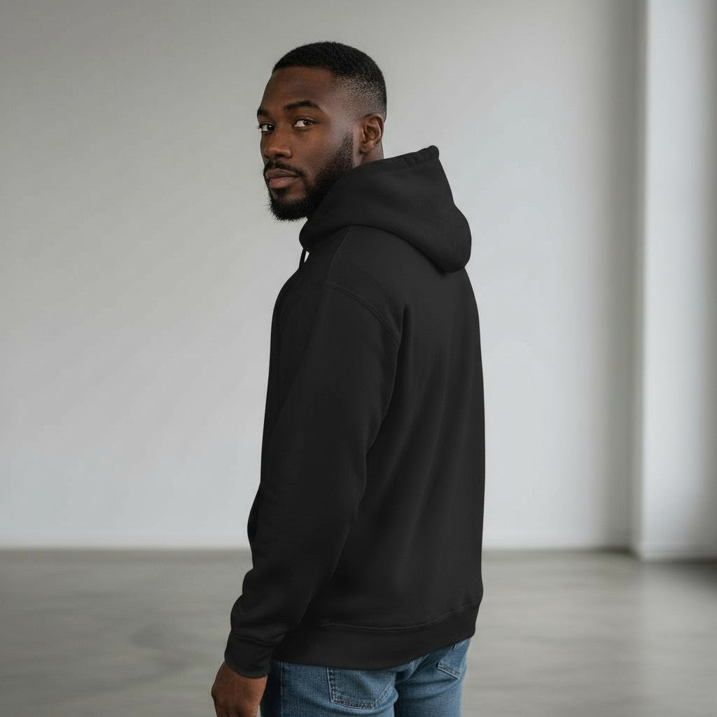 Man wearing a black hoodie in a minimalistic setting