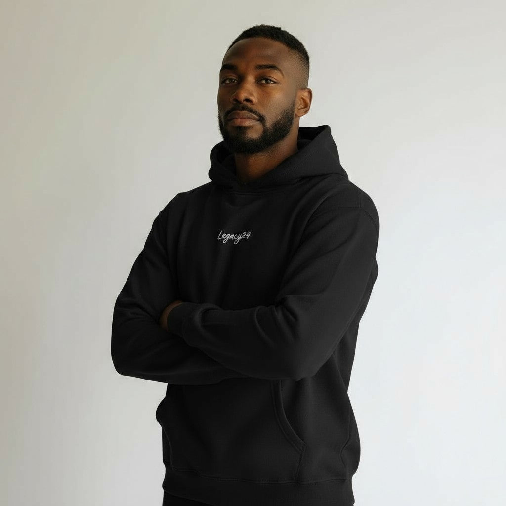 Man wearing a black hoodie with legacy29 logo on a plain background
