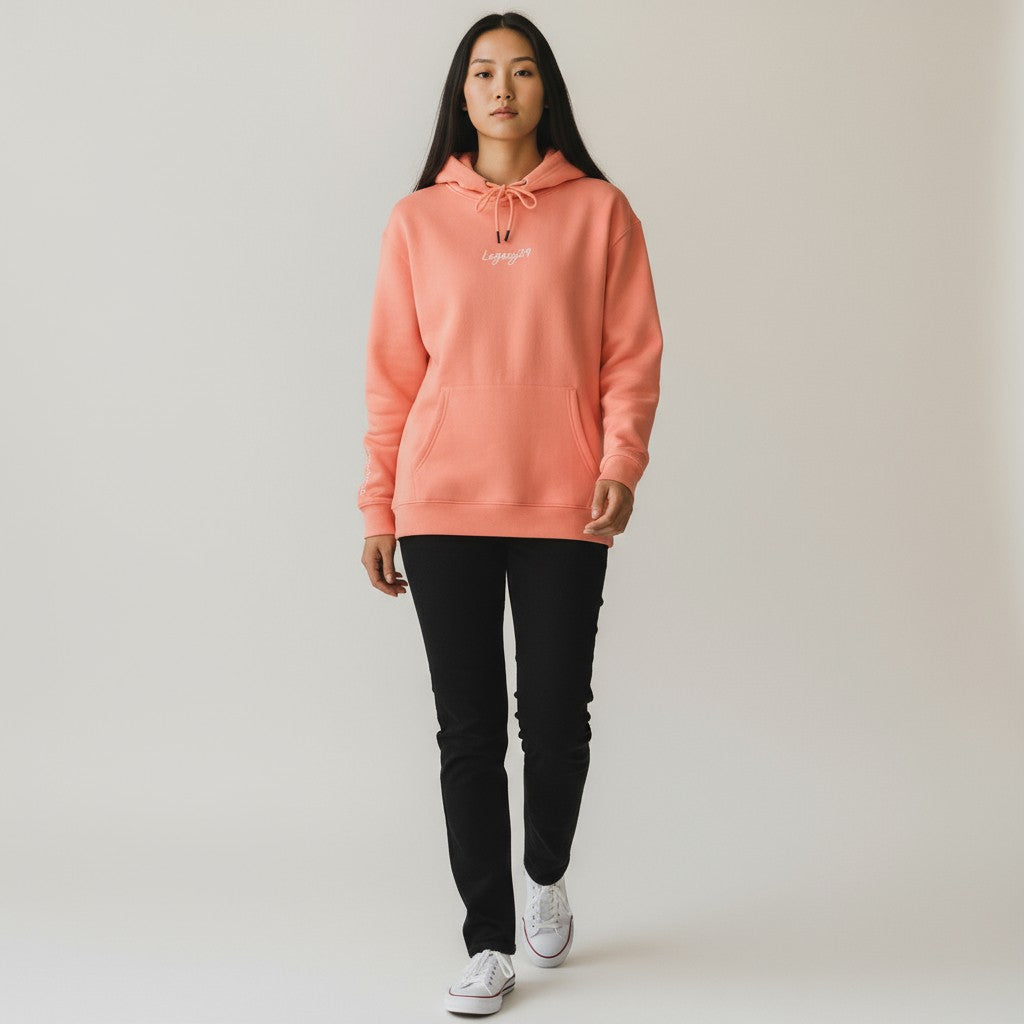 Person wearing a coral hoodie with a logo on a plain background