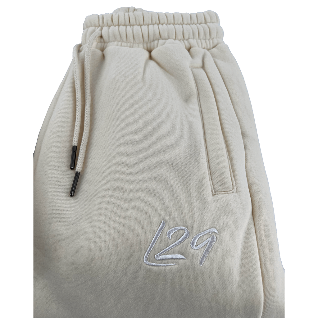 Legacy29 Junior Cream Tracksuit Bottoms with embroidered L29 logo and adjustable drawstring waist. Soft and comfortable for everyday wear.