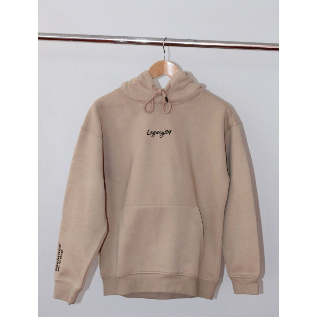 Legacy29 Desert Dawn Beige hoodie hanging on a wooden hanger, showcasing its minimalist design and premium fleece-lined cotton fabric.