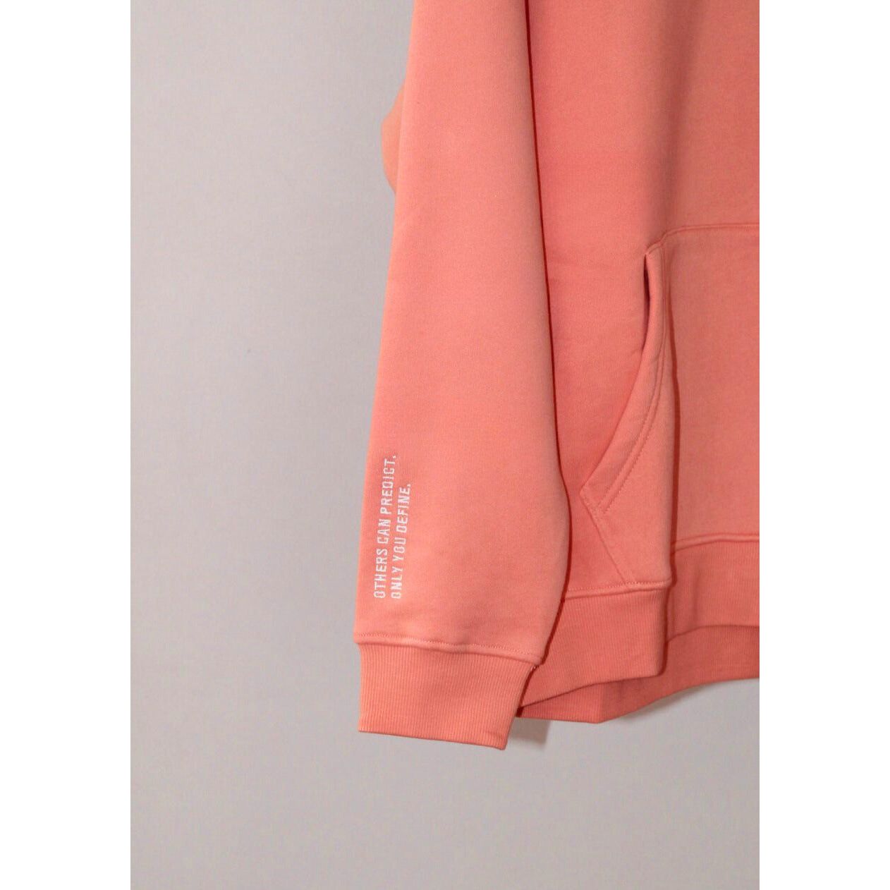 Close-up of the sleeve detail on the Legacy29 Resilience Collection: Confident Coral Hoodie, featuring an inspirational printed quote.