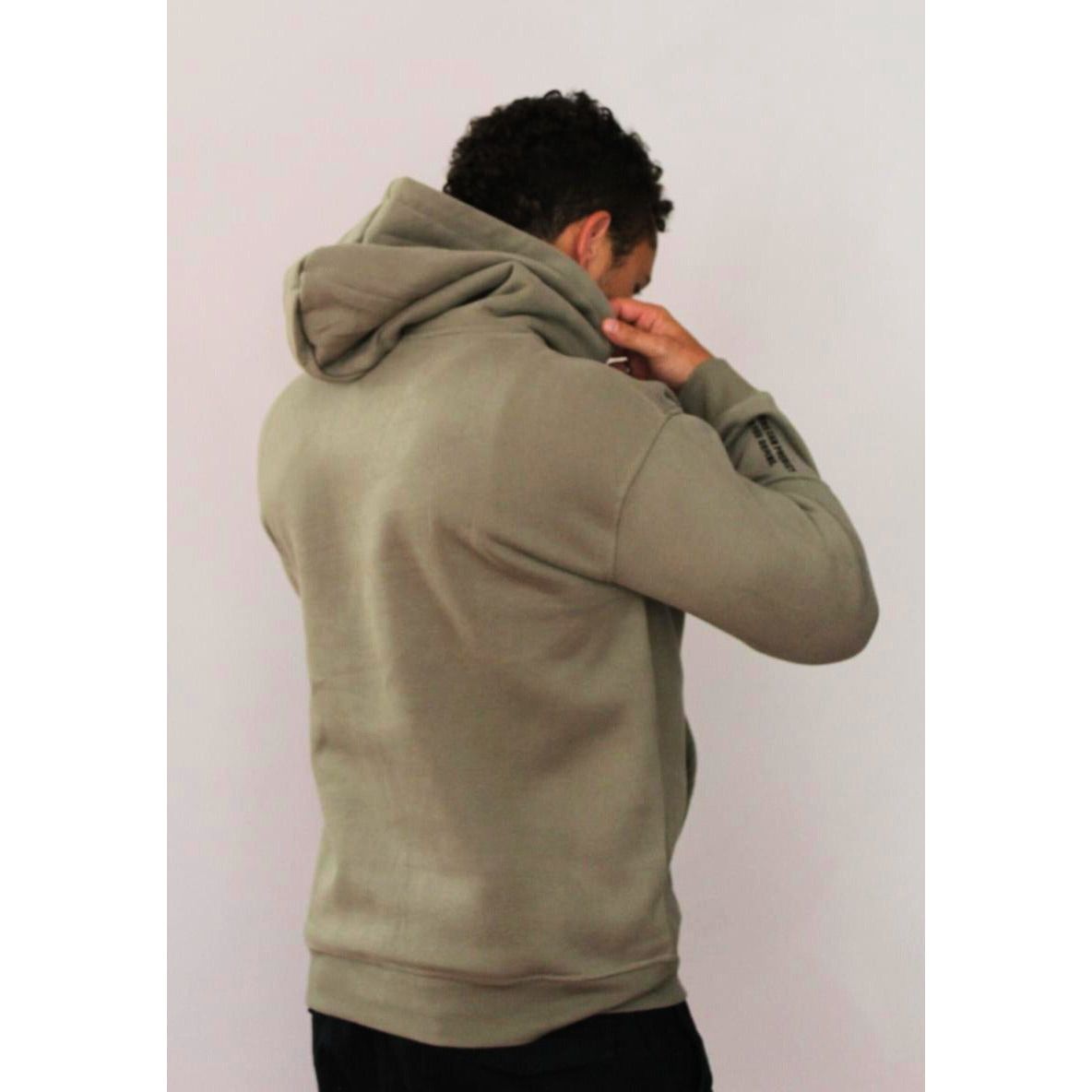 Back view of man wearing Legacy29 Grateful Green hoodie, showcasing relaxed fit and hooded design for warmth and everyday wear.