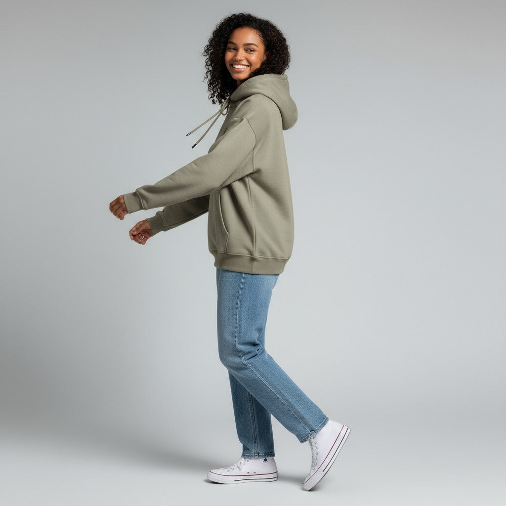 Person wearing a green hoodie and blue jeans on a gray background