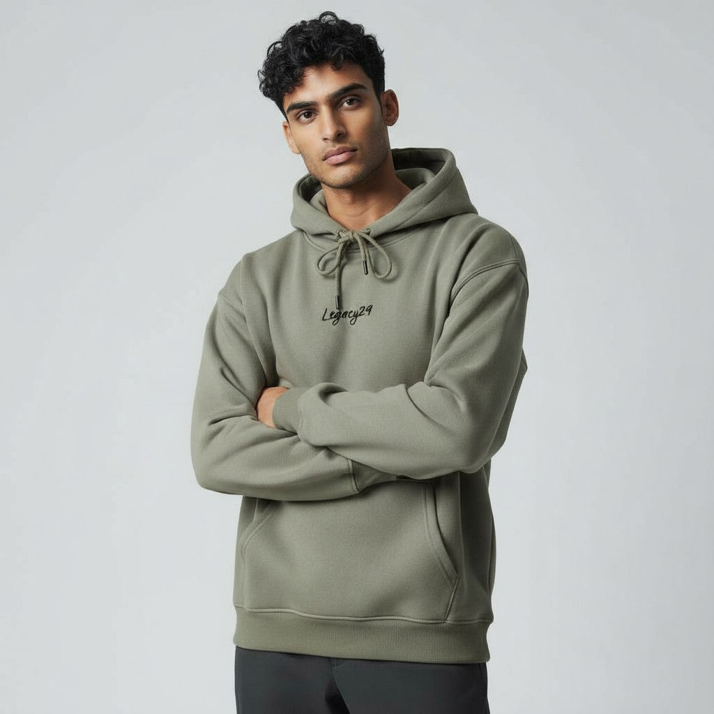 Man wearing a green hoodie with a brand logo on a light gray background