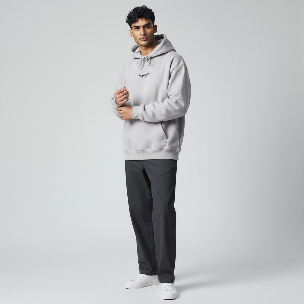 Person wearing a light gray hoodie with a brand logo on a plain background