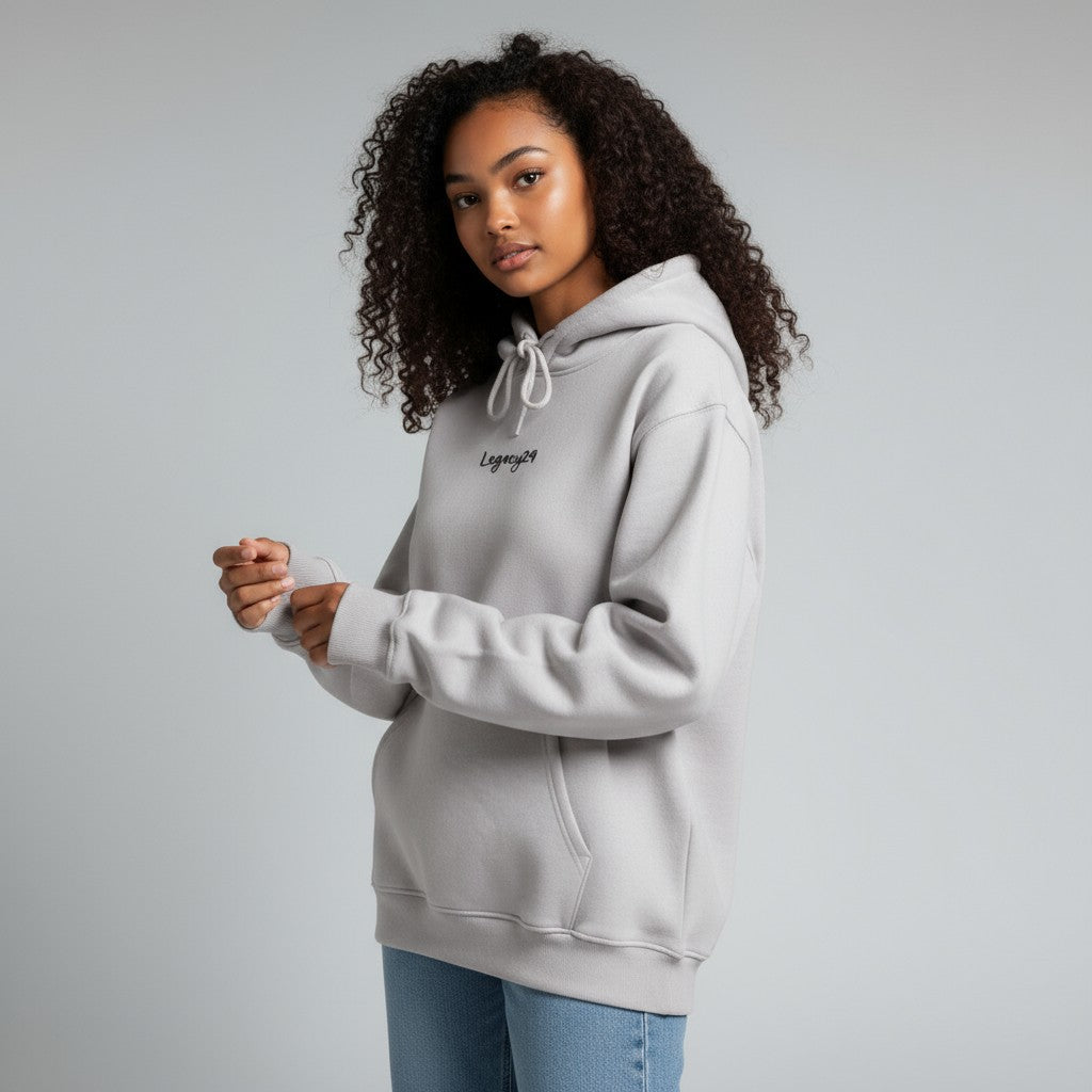 Woman wearing a gray hoodie with text on a plain background