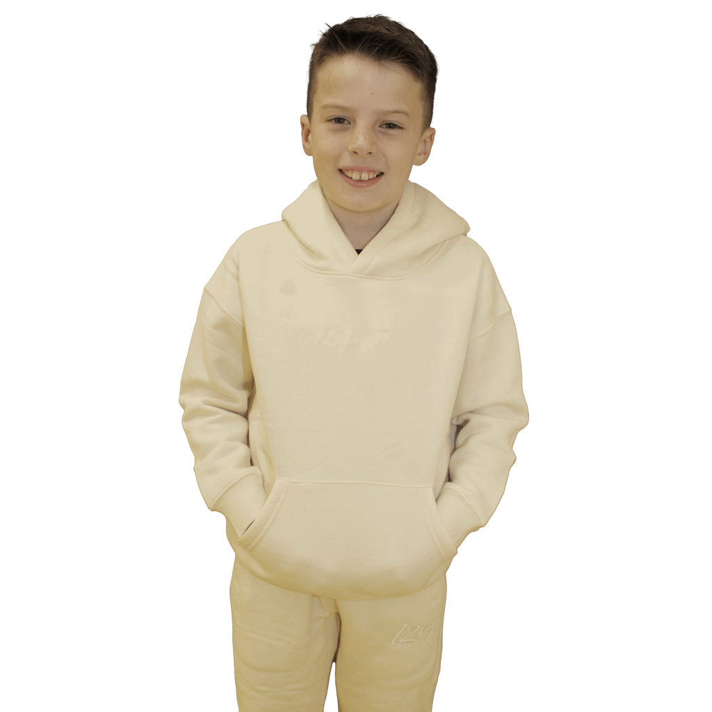 Child wearing Legacy29 Junior Cream Comfort Set, including hoodie and tracksuit bottoms. A cosy and stylish outfit for kids.