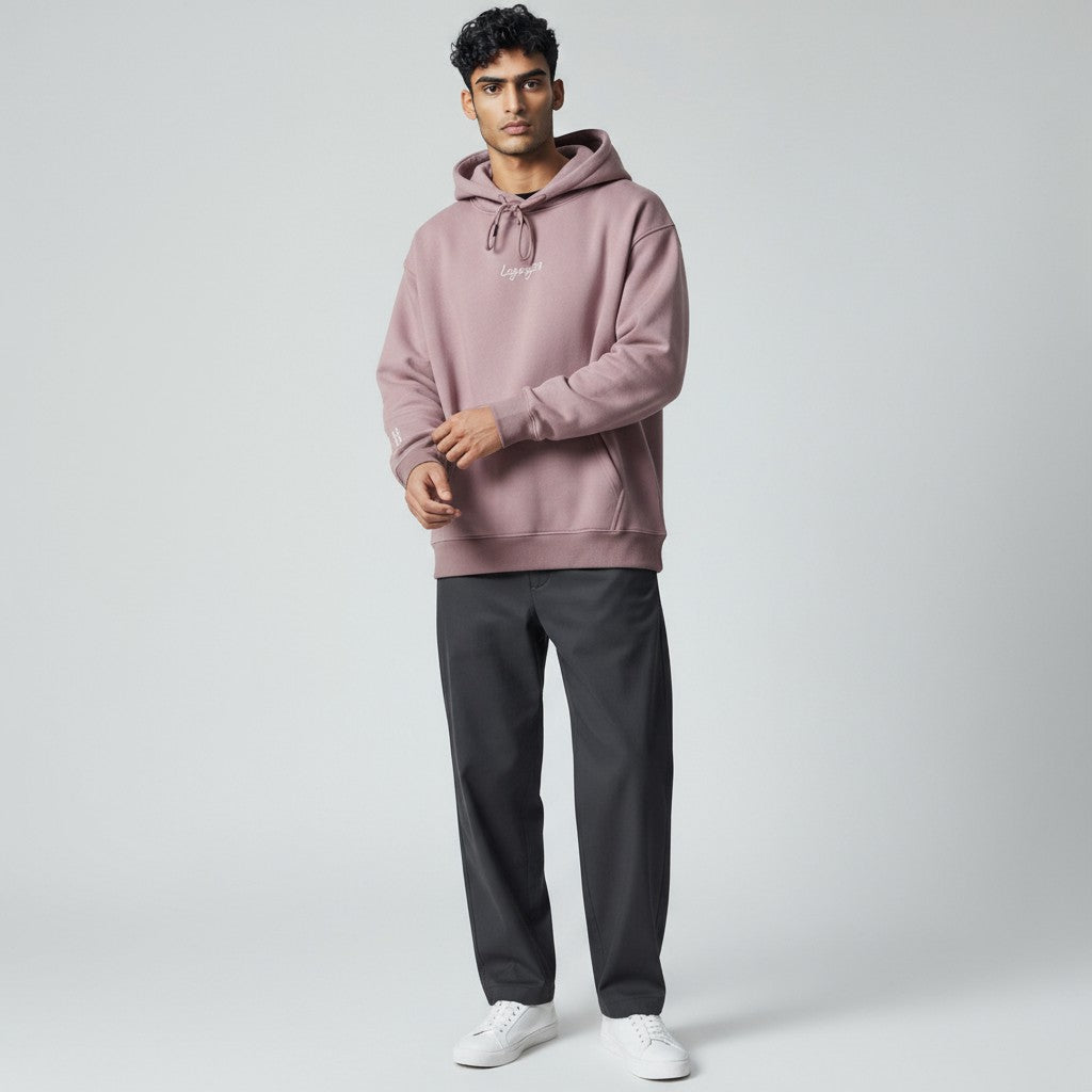 Man wearing a lavender hoodie and black pants on a light gray background