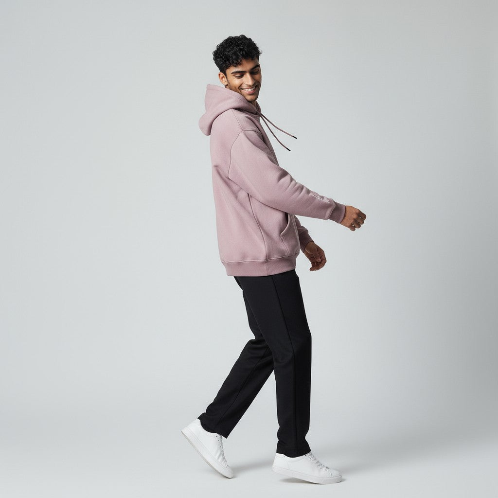 Person wearing a lavender hoodie and black pants on a light gray background
