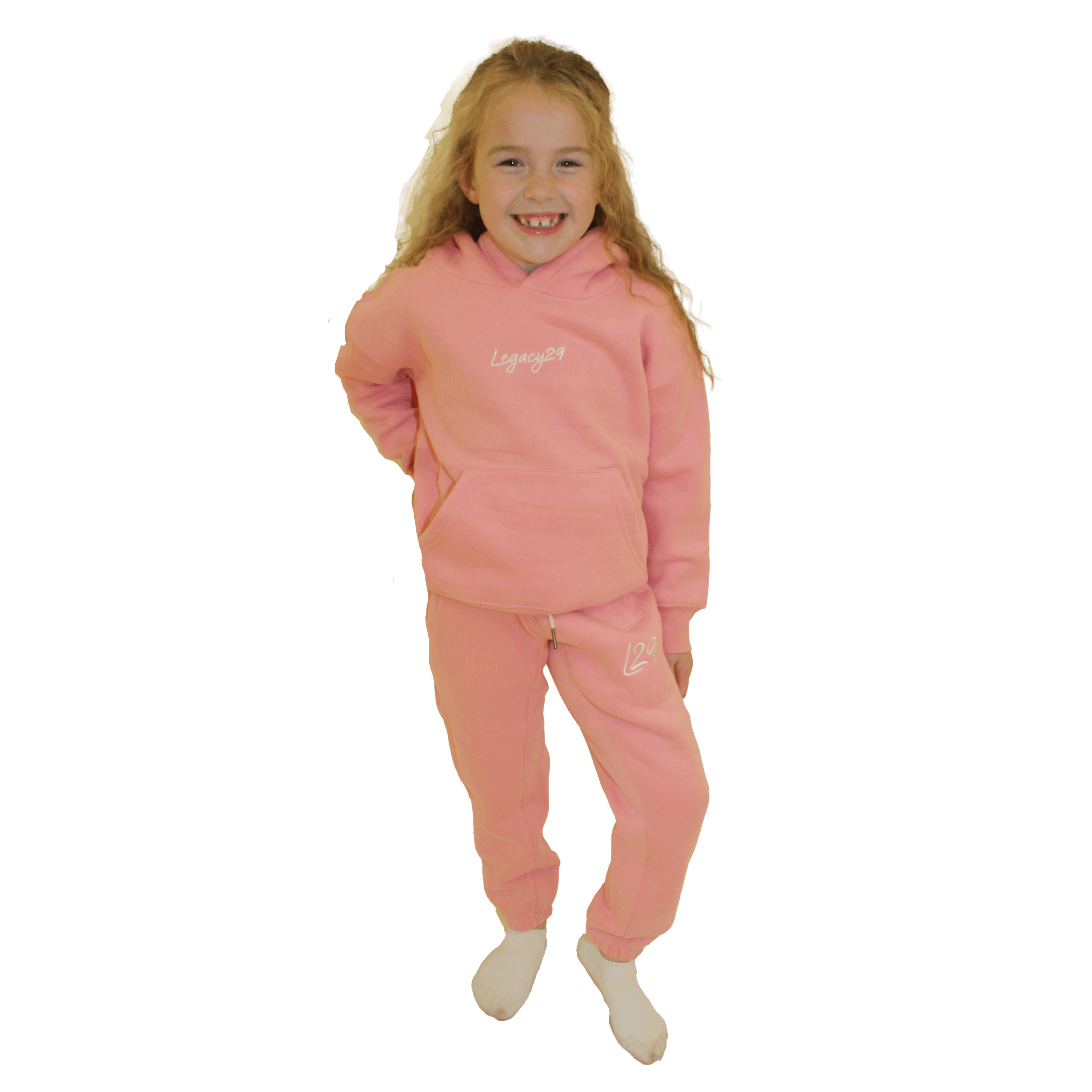 Young girl wearing the Legacy29 junior pink hoodie and tracksuit bottoms set. Comfortable and trendy kids' outfit.