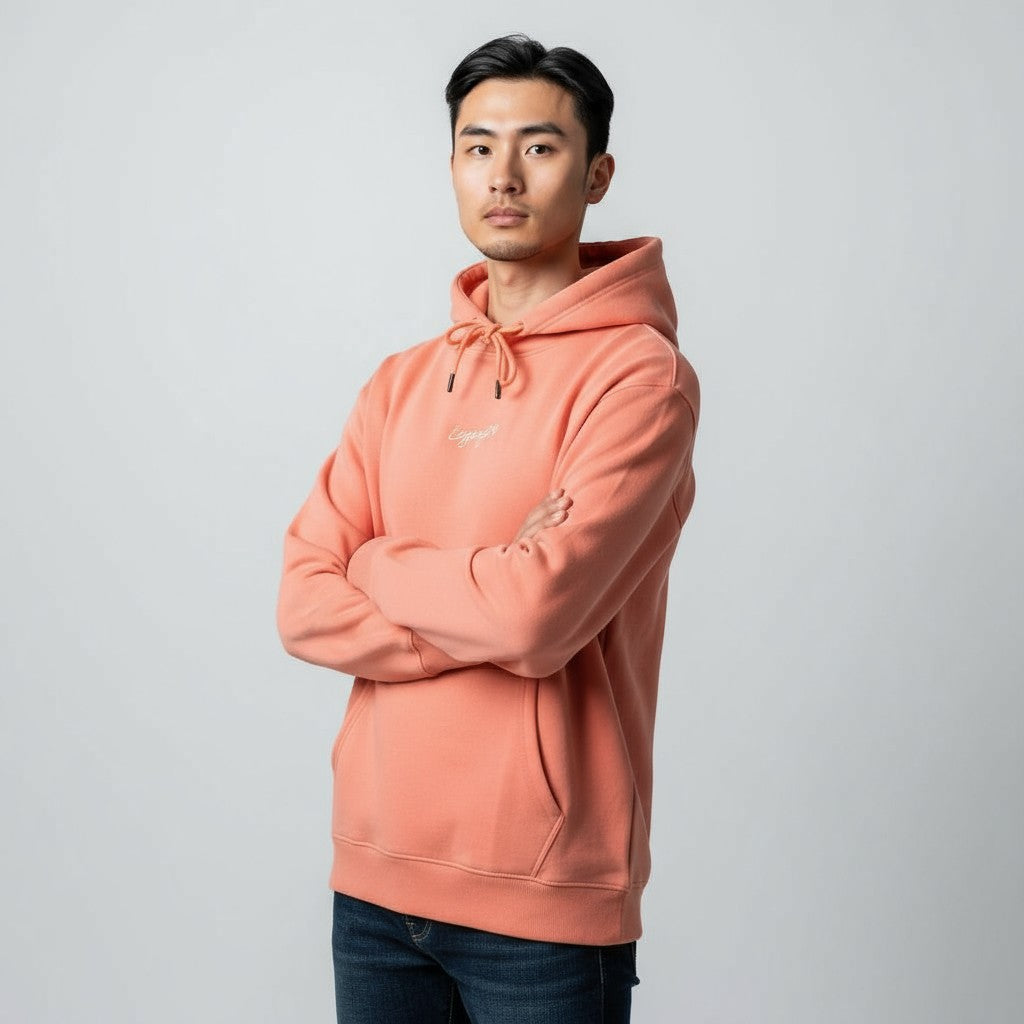 Person wearing a peach-colored hoodie against a plain background