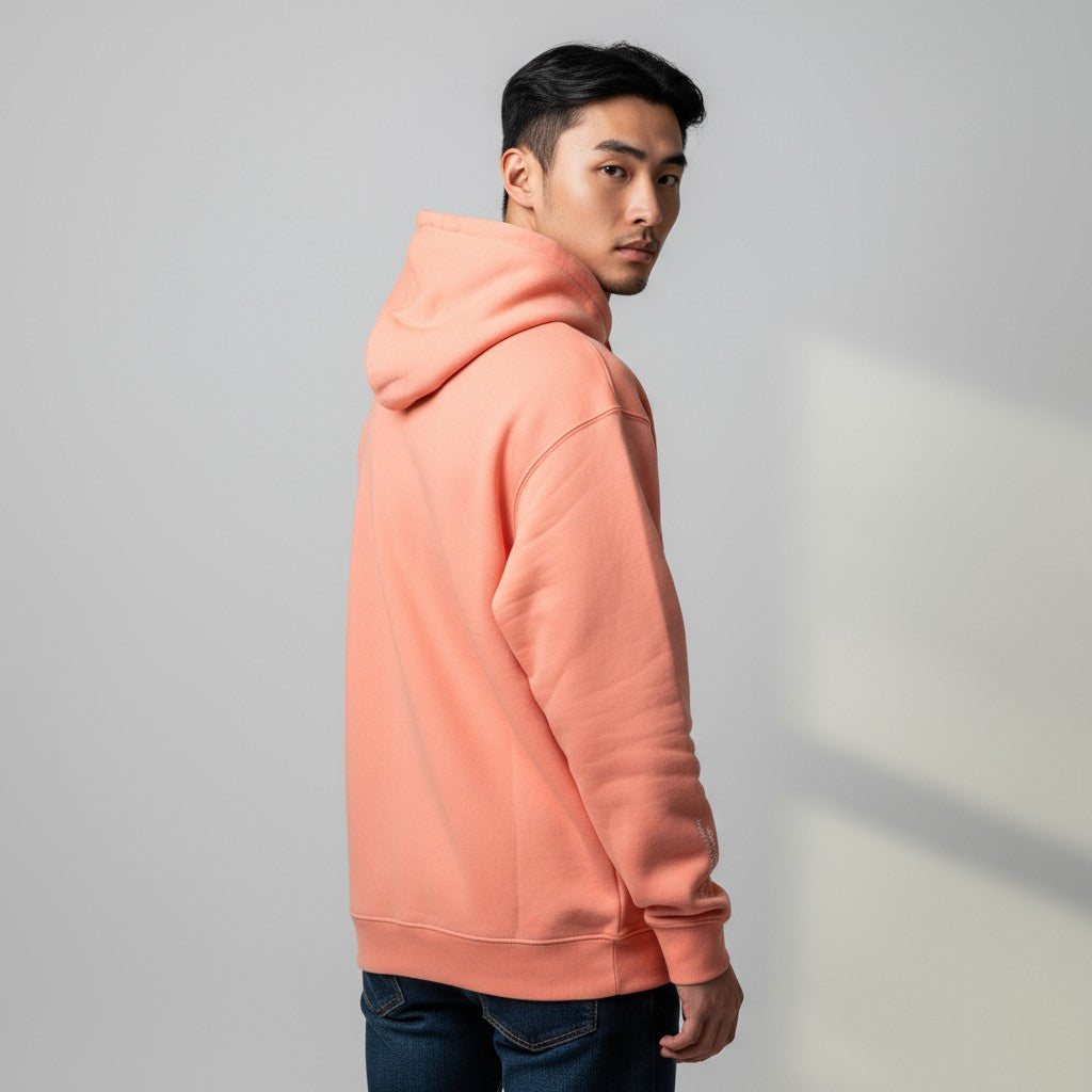 Person wearing a peach-colored hoodie against a plain background
