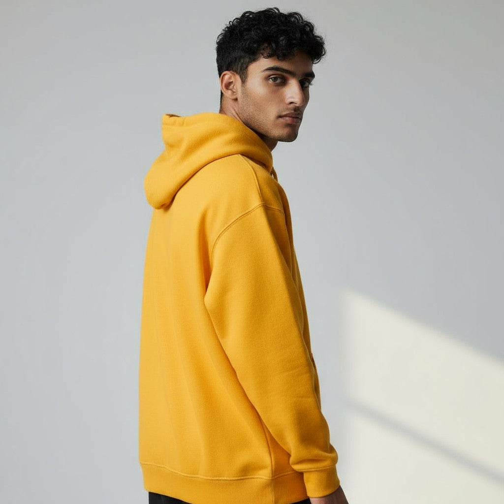 Man wearing a yellow hoodie against a plain background