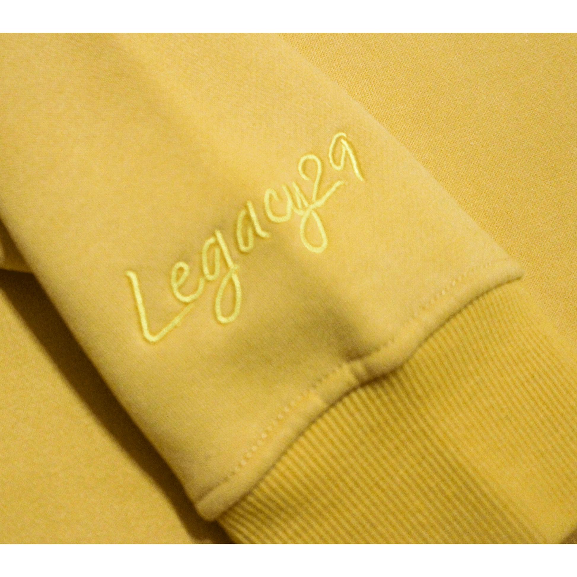 Legacy29 embroidered logo on sleeve of yellow jumper